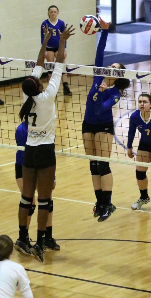 Taylor challenges the middle blocker with her quick attack.